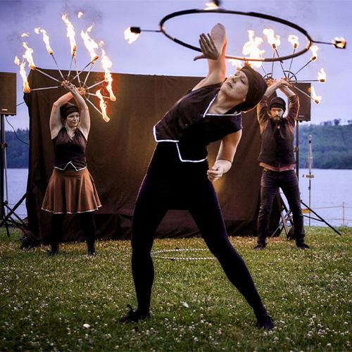 Funkenspiel Feuershow drei Menschen, die Kunststücke mit brennenden Fackeln machen