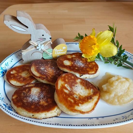 F&uuml;nf Struwen (Hefepfannkuchen) mit Apfelmus auf einem Teller, Osterhasenfigur links, Gelbe Narzisse rechts