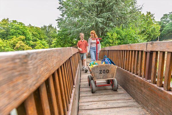 Eine Familie läuft mit einem Bollerwagen durch den Zoo in Münster