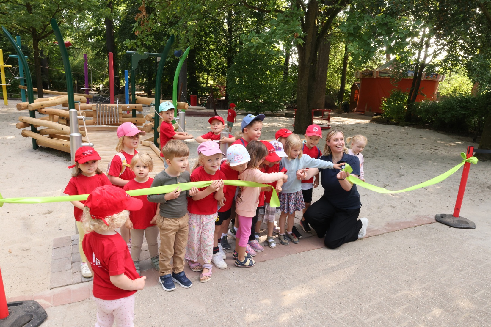 Eine Gruppe Kinder und Direktorin Schehka stehen vor einem gerade durchschnittenen Band