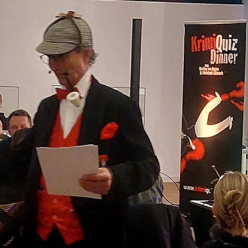 Ein als Sherlok Holmes verkleideter Schauspieler, der durch die Reihen der Teilnehmenden des Krimi Quiz Dinners geht.